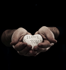 two hands holding a stone with the inscription I love you